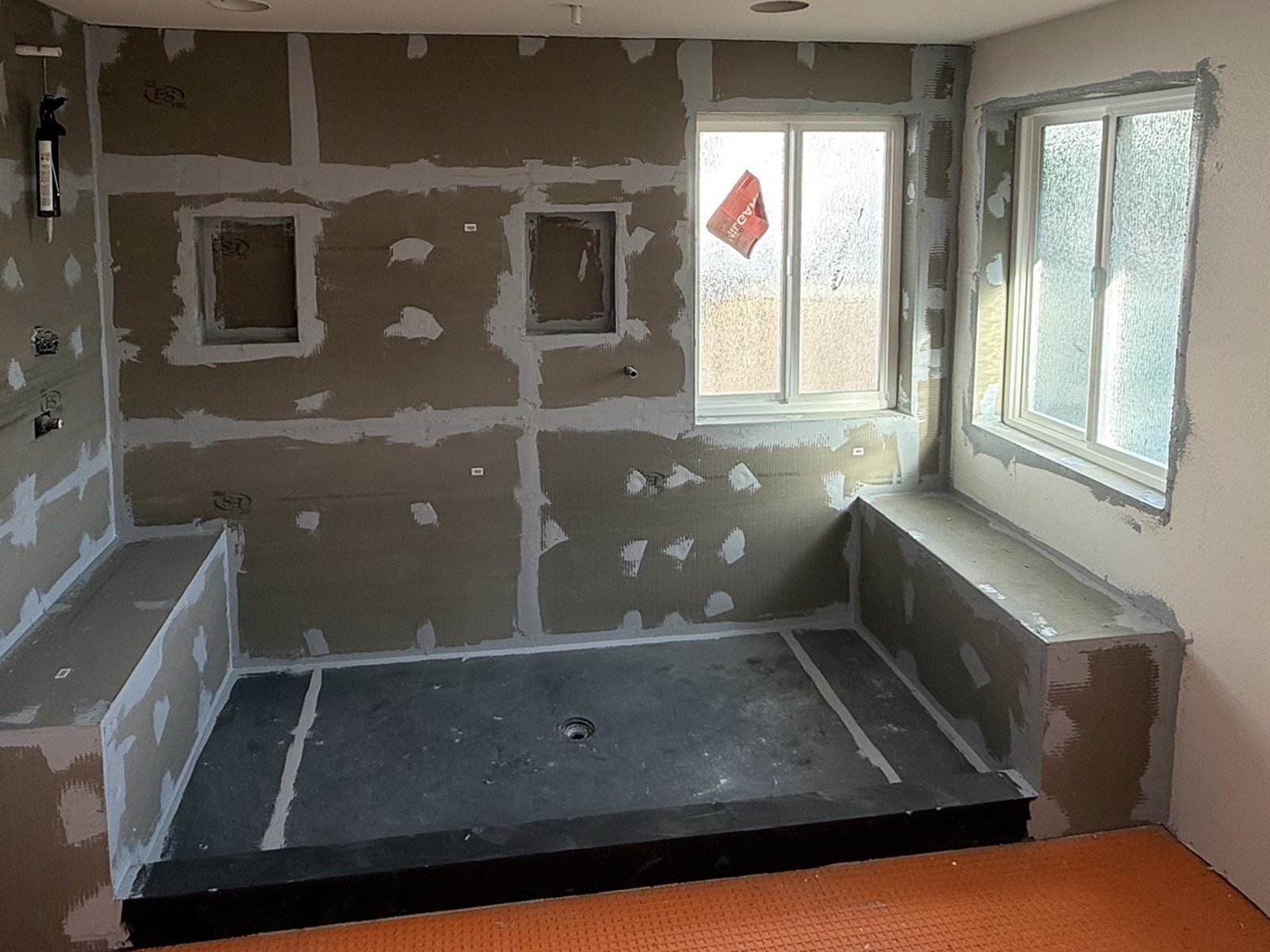 Before: the same shower with waterproof backer board, sealed seams and floor membrane before tiling