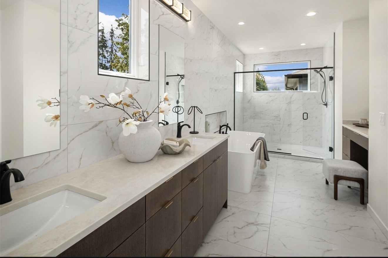 After: finished master bathroom with marble-look tile, double vanity and walk-in shower
