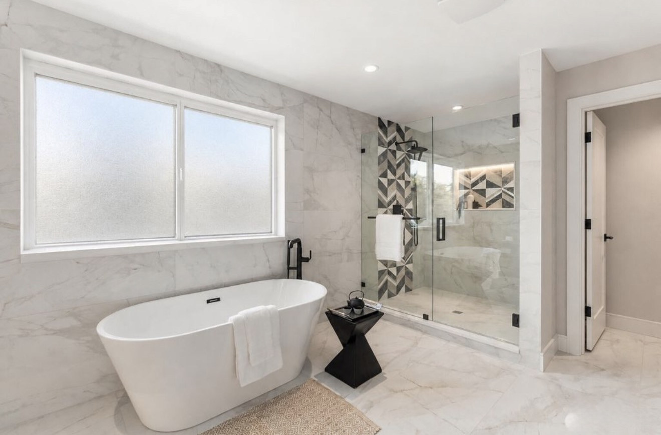 Glass shower with chevron tile accent strip and tile niche