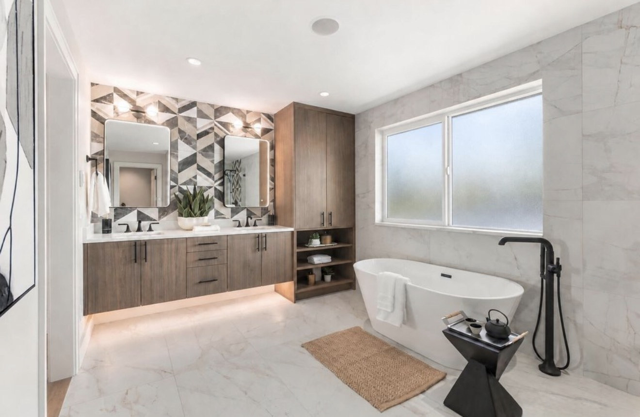 Master bathroom with marble tile walls, chevron tile accent wall and freestanding tub in Issaquah, WA
