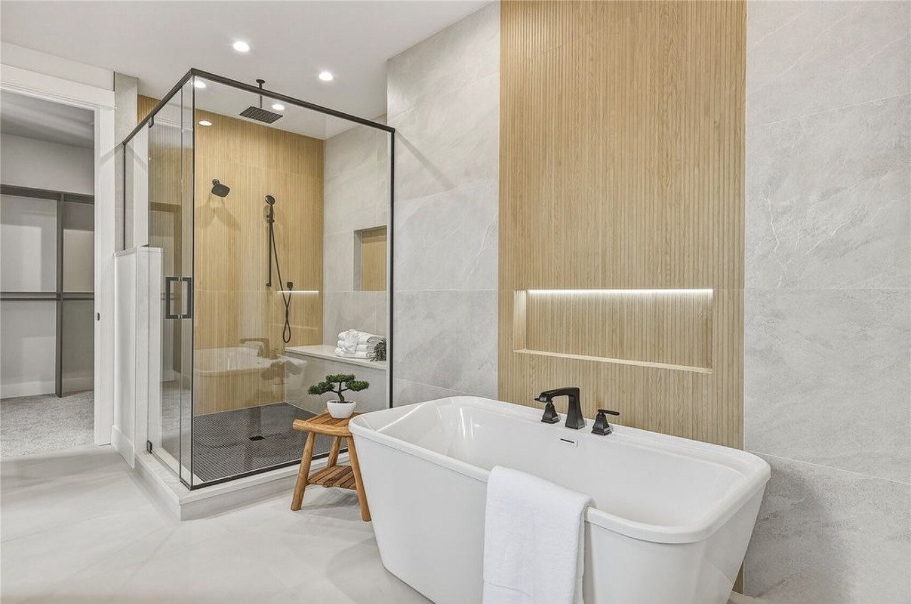 Wood-look tile feature wall with lit niche beside a freestanding tub