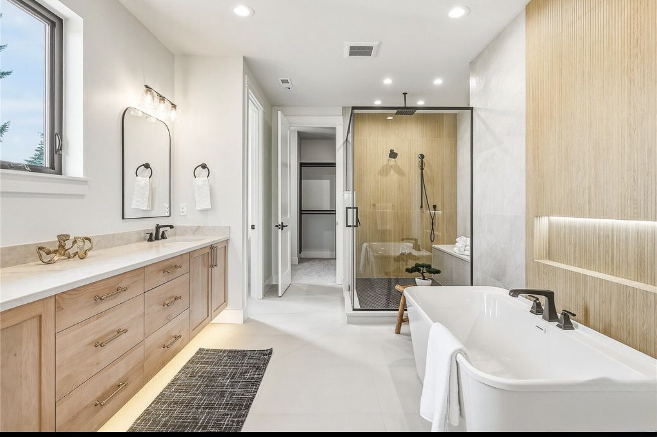 Glass-enclosed shower with wood-look vertical tile and large format floor tile